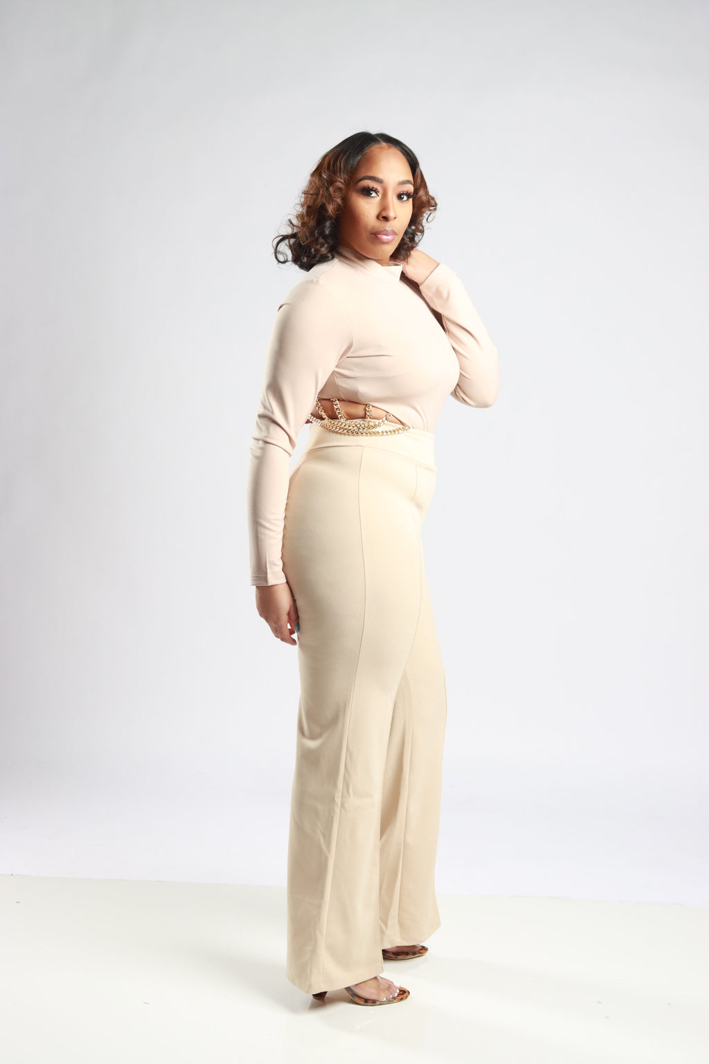 Side details showcasing the flare and the beauty of the whole outfit. Beige pants, perfect for any pairing, full-length.