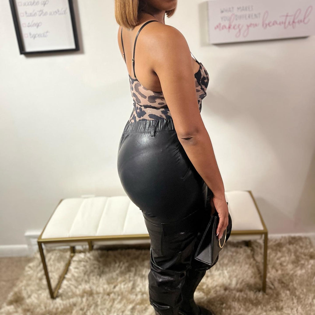 Black full length flared faux leather pants with cargo pockets.